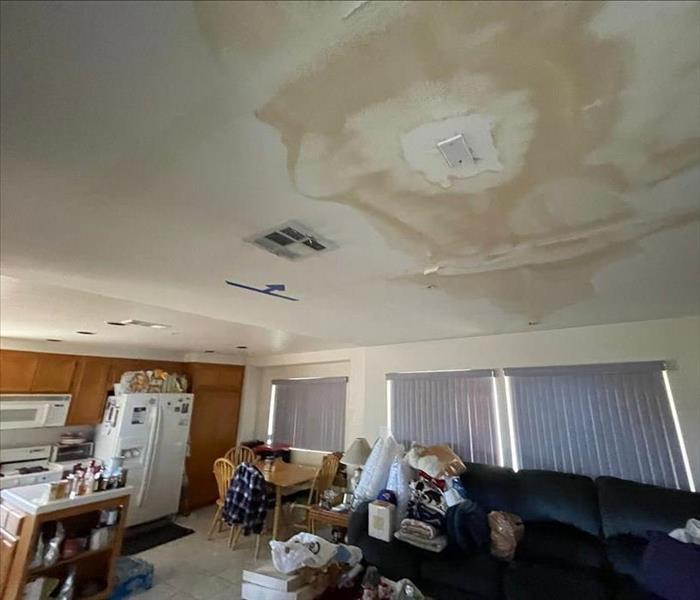 A heavily stained, water-damaged living room ceiling 