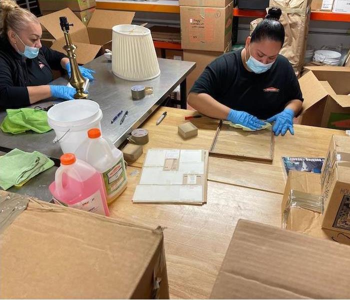 SERVPRO technicians with cleaning solutions and boxes for home contents