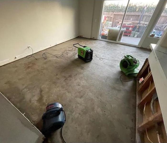 Air movers and dehumidifier near kitchen counter with flood cuts, baseboards removed