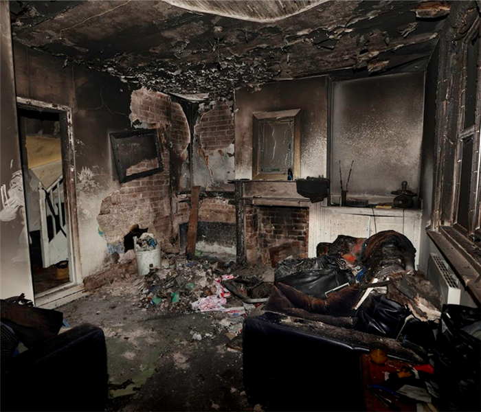 a fire damaged living room with debris and soot everywhere