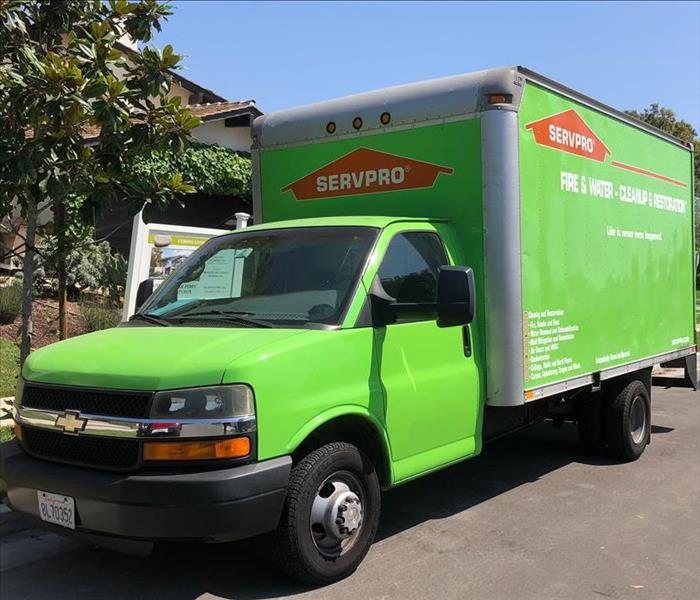 SERVPRO Green Box Truck Parked on street with tree on left side
