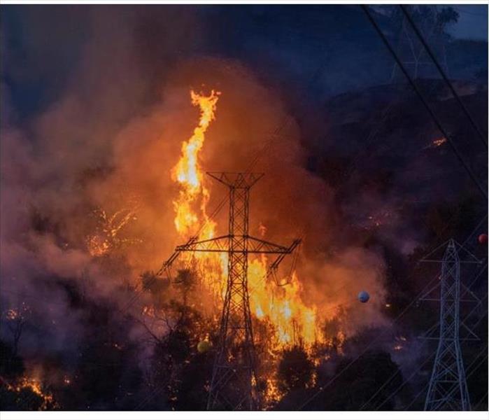 Vivid scene of blazing wildfire with an electrical tower