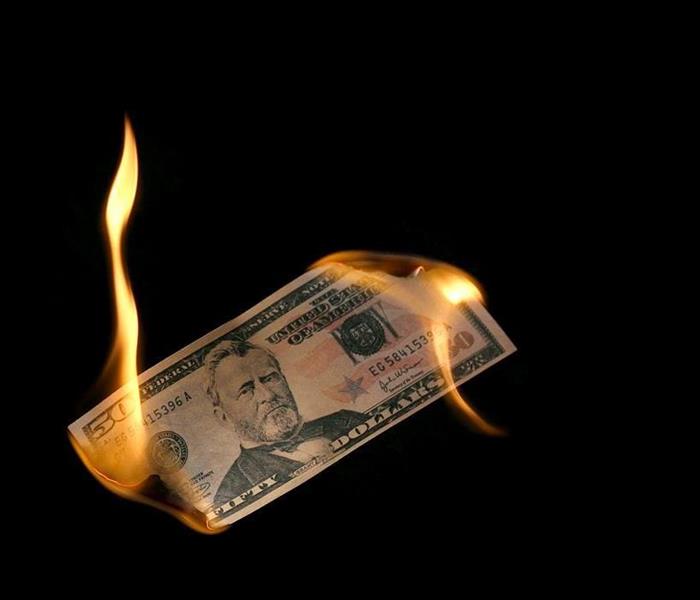 fifty dollar bill burning with flames