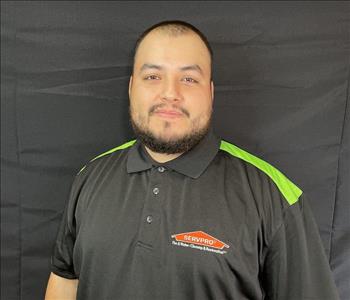 male posing, servpro black shirt, and background
